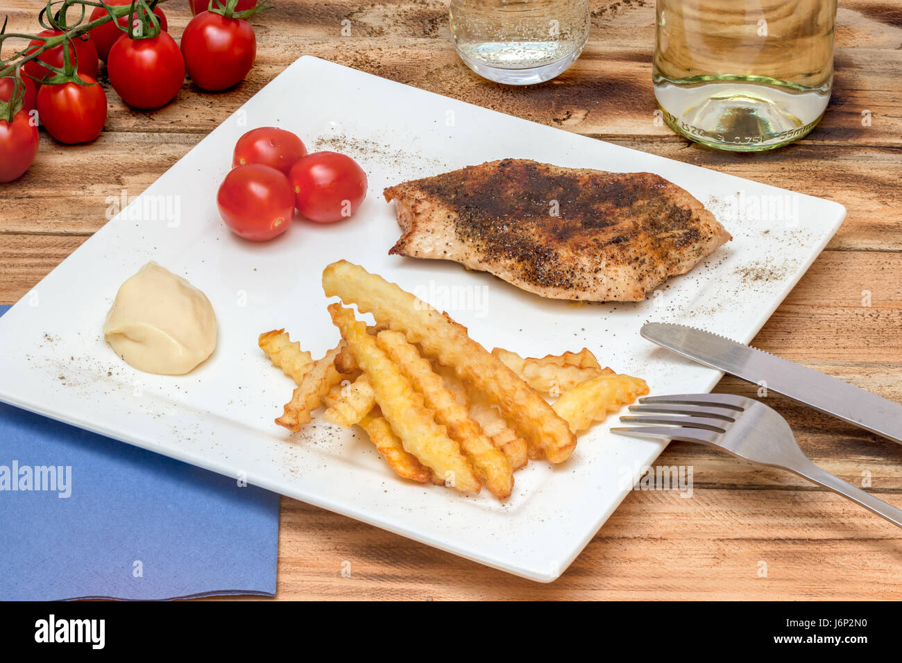 Fries with chicken fillet and bunch of tomatoes Stock Photo