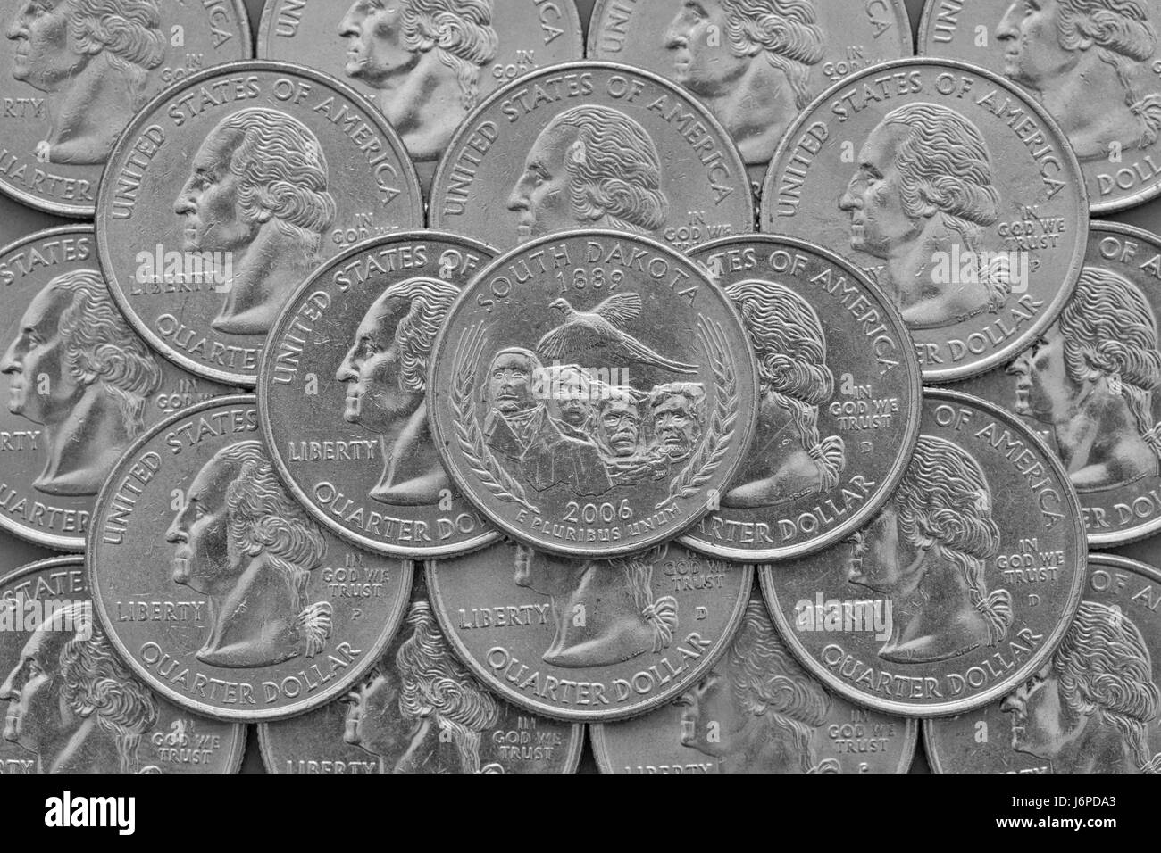 South Dakota State and coins of USA. Pile of the US quarter coins with George Washington and on the top a quarter of South Dakota State. Stock Photo
