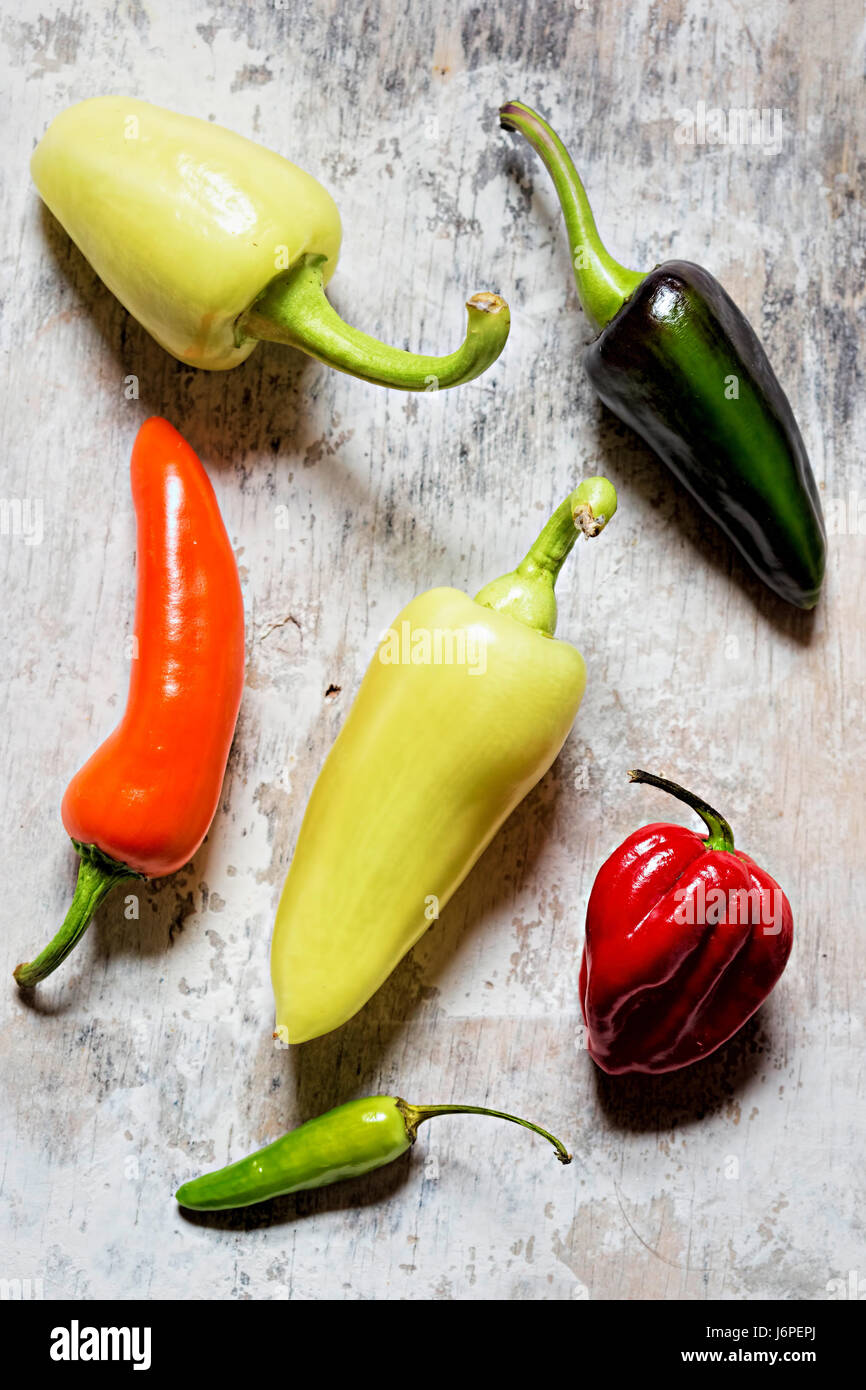 Green, red, yellow and orange peppers on white background Stock Photo