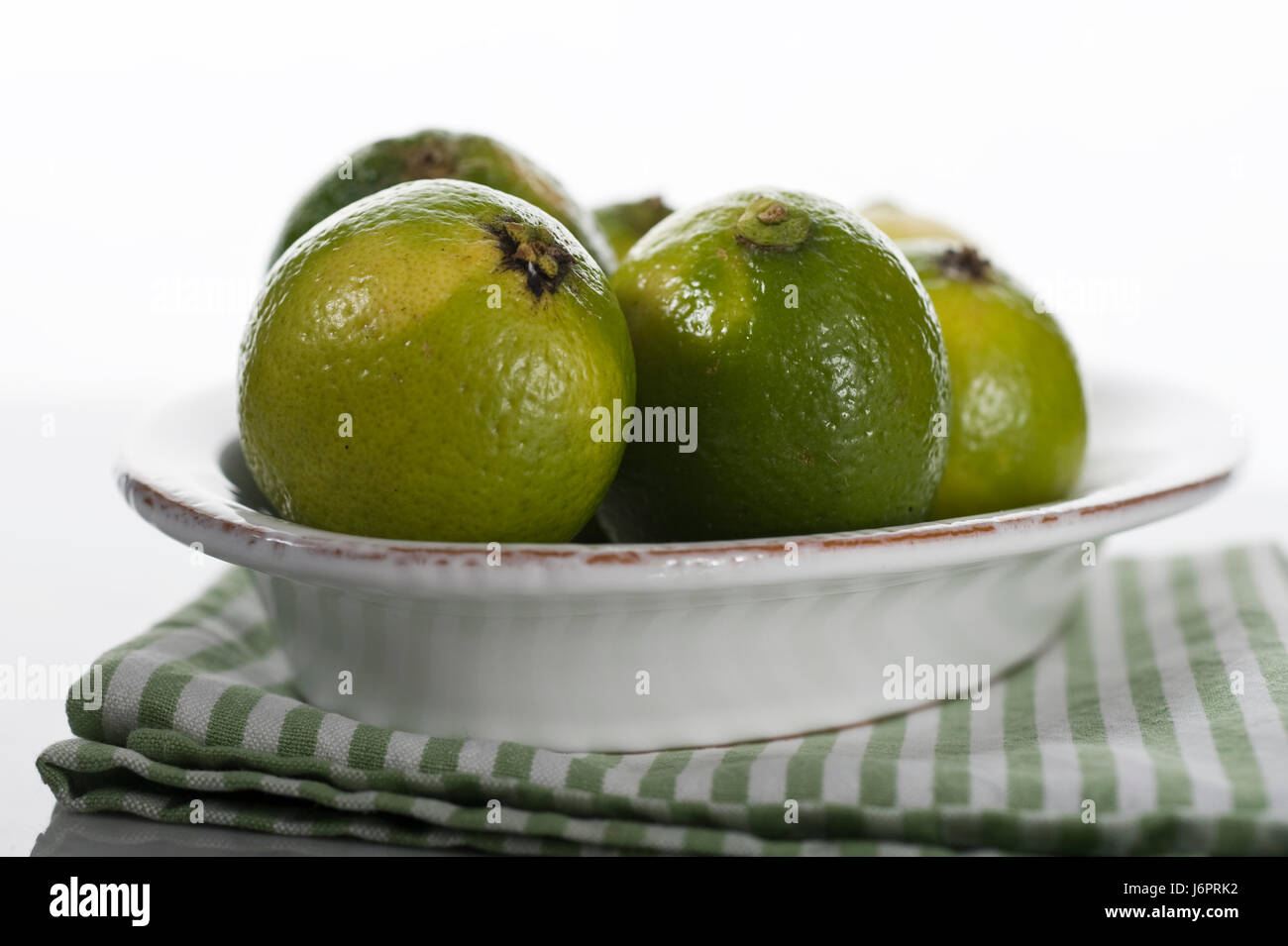 green fruit china bowl lemons lime harness green striated fruit south citrous Stock Photo