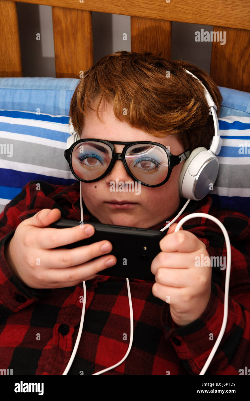 Boy From Belarus Is Using His Smart Phone Indoors Stock Photo