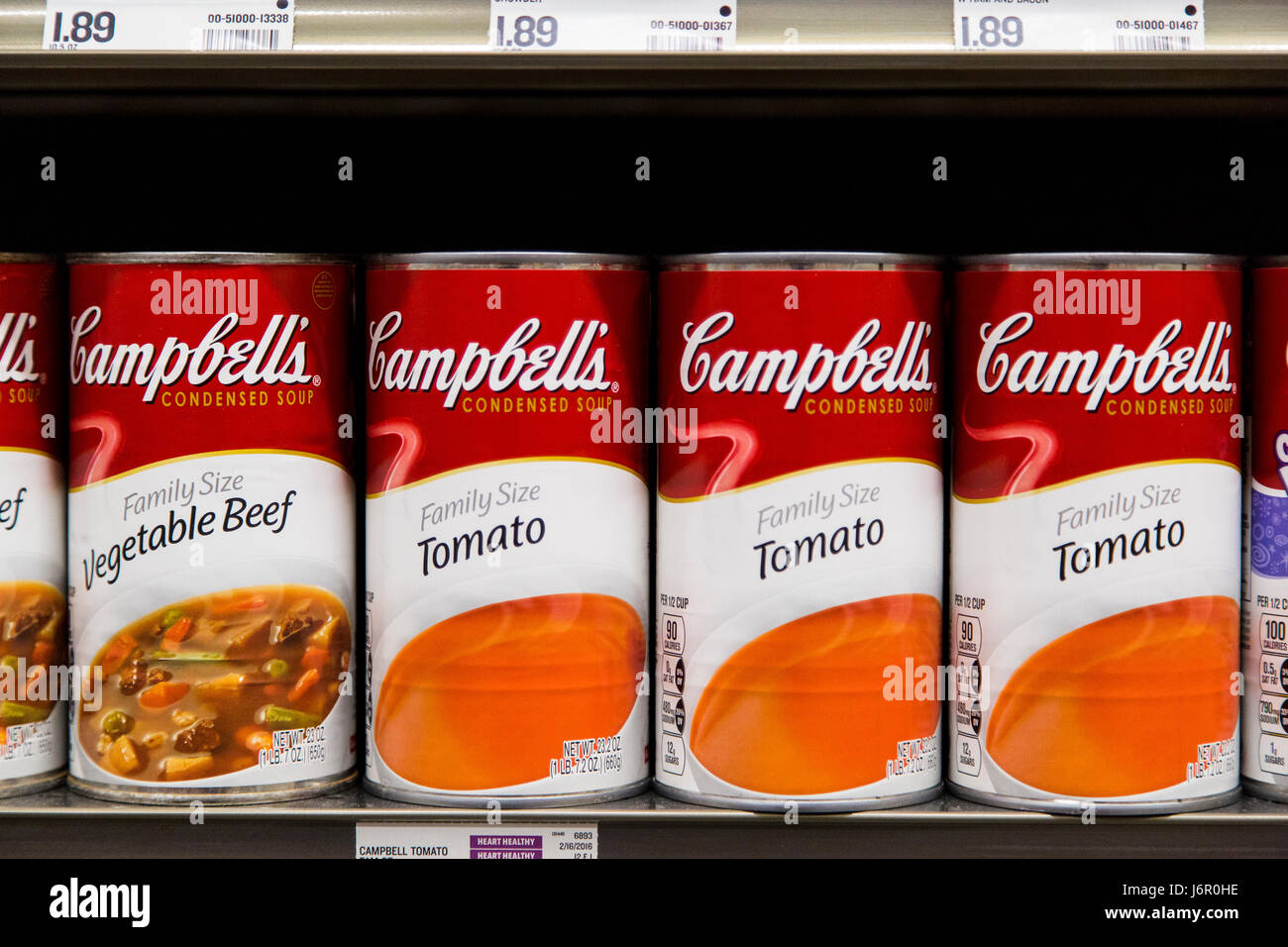rows of Campbell's brand soup cans on the shelves of a grocery store Stock Photo