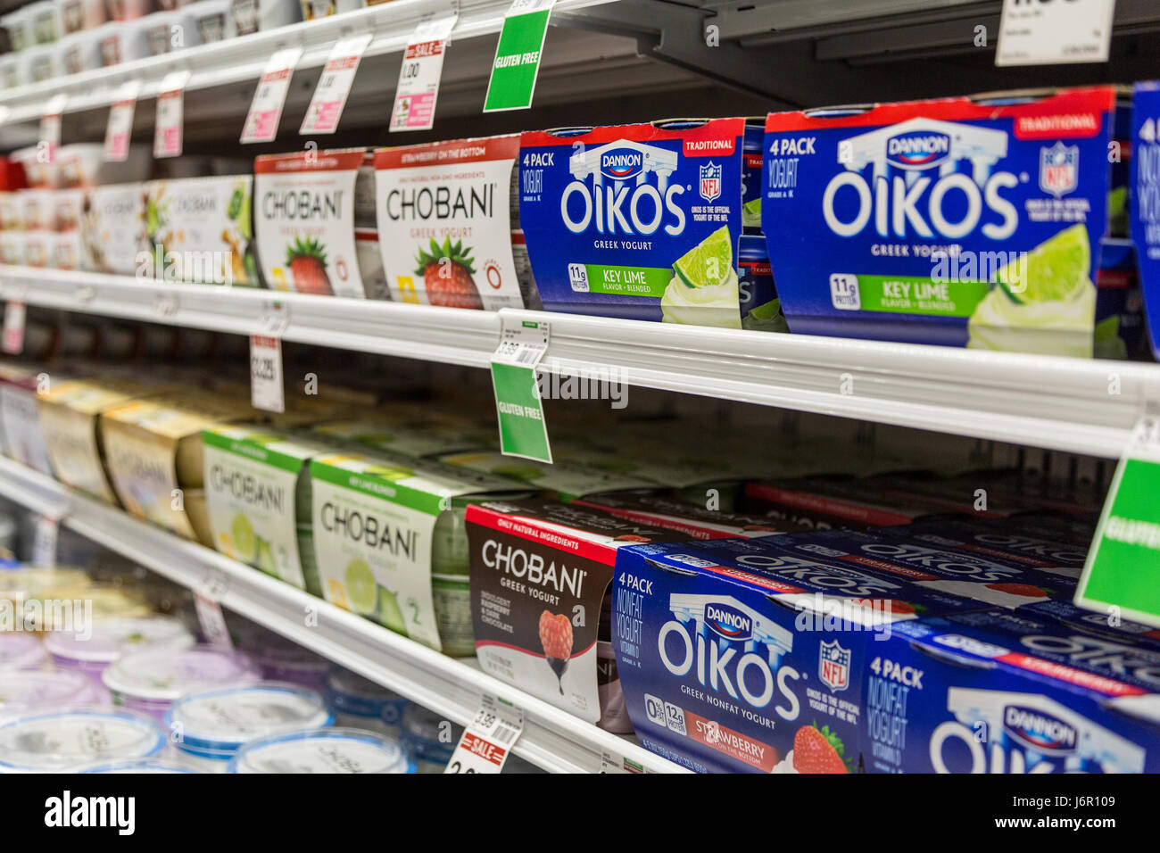 Cartons of Oikos and Chobani brand yogurt on the shelves of a