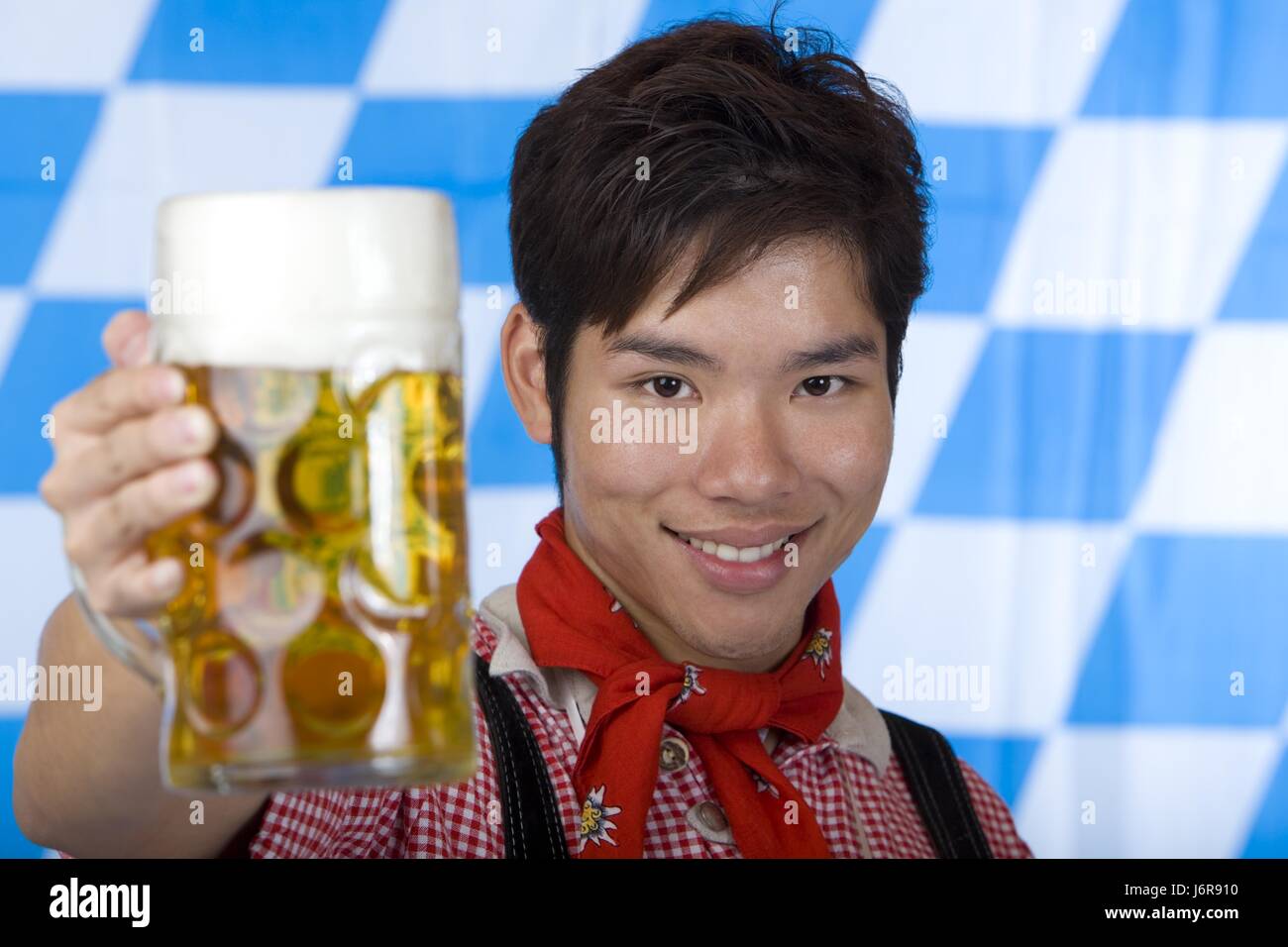 asian holds oktoberfest beer stein into camera Stock Photo