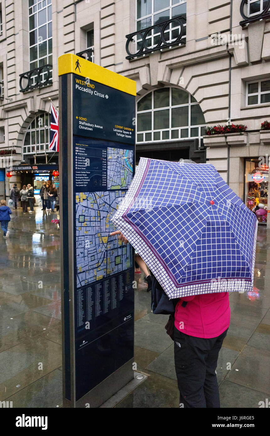 Tourist With Umbrella Looking At Public Map At Piccadilly Circus Stock Photo Alamy