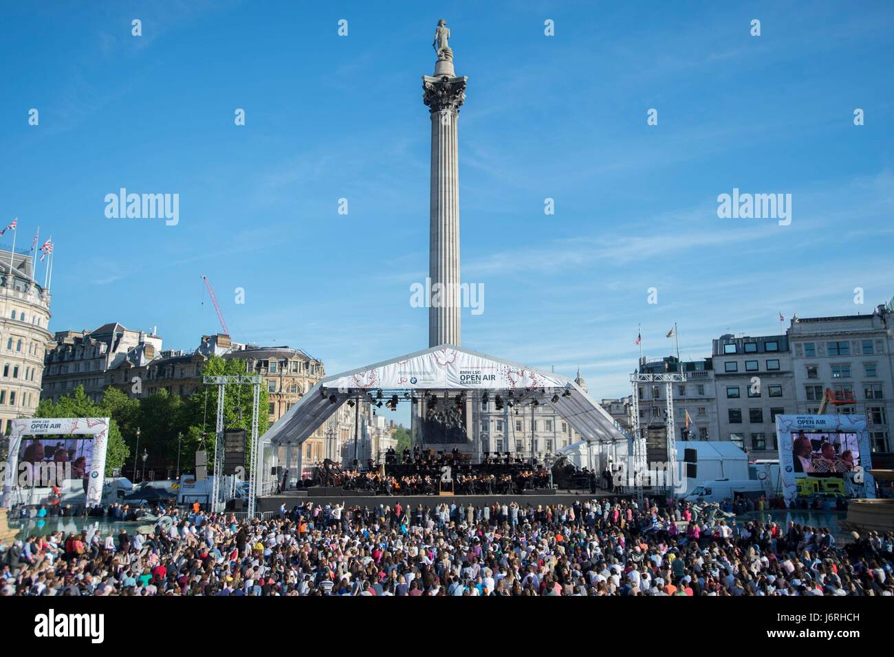 Members of the public watch the London Symphony Orchestra play a programme of Rachmaninov in Trafalgar Square, central London. Stock Photo