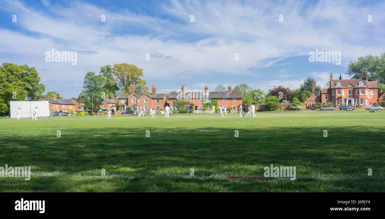 Village cricket being played on the green at Hartley Wintney in Hampshire, UK Stock Photo