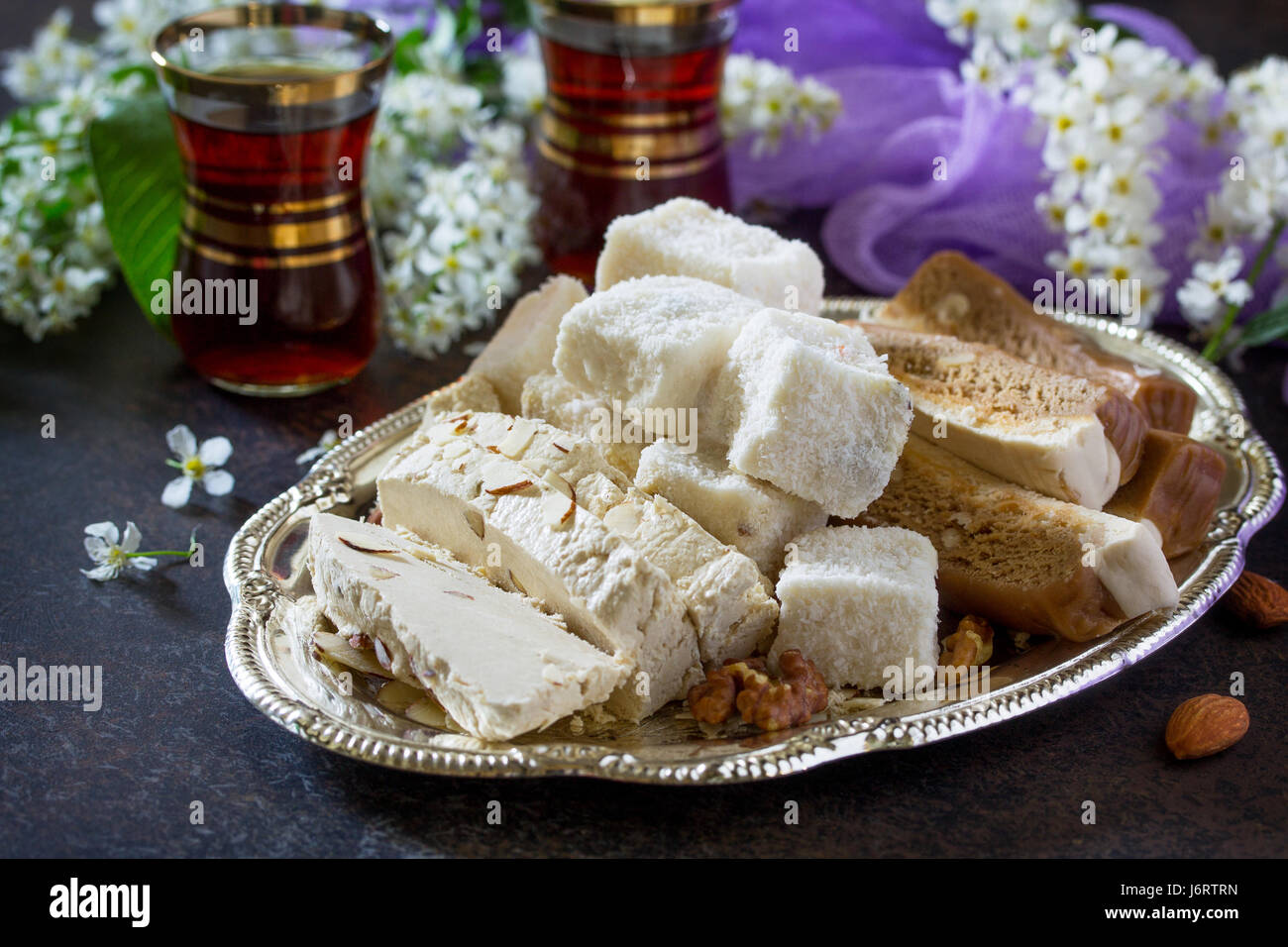 Rahat Lukum, sherbet, halva and tea on the kitchen table. Turkish and Arabic sweets. Ramadan food. Stock Photo