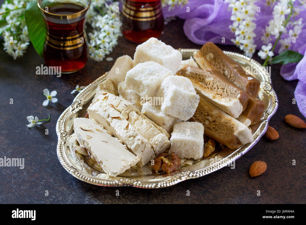 Rahat Lukum, sherbet, halva and tea on the kitchen table. Turkish and Arabic sweets. Ramadan food. Stock Photo