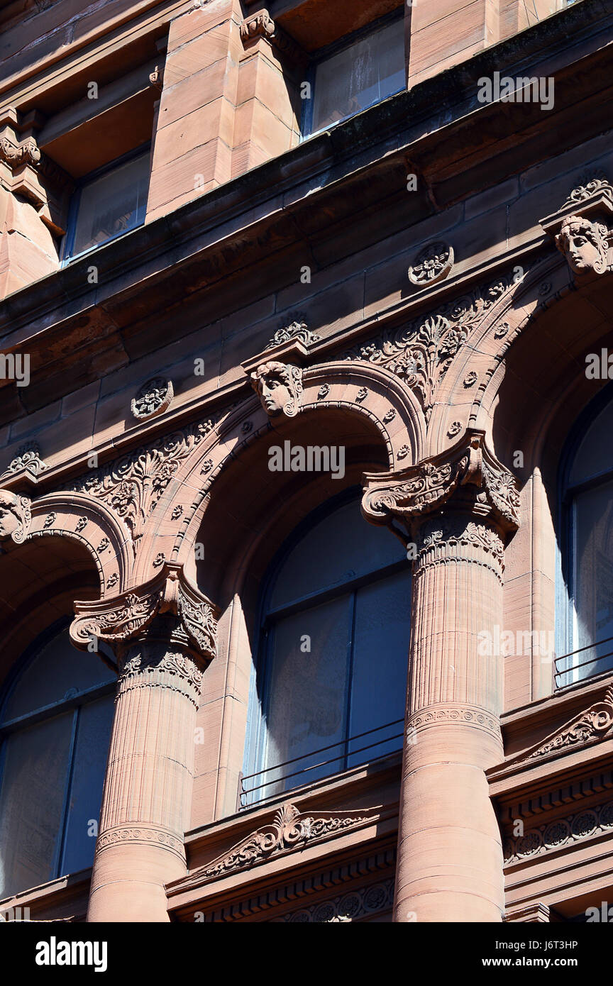 Glasgow Scotland's Victorian Architecture: columns, decorated frieze and keystoned lintels from an 1895 red sandstone commercial building Stock Photo