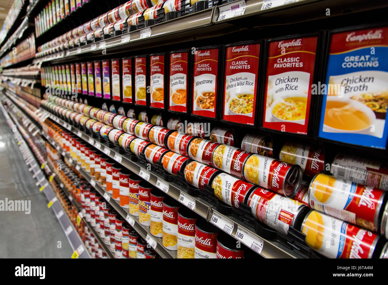 rows of Campbell's brand soup cans on the shelves of a grocery store