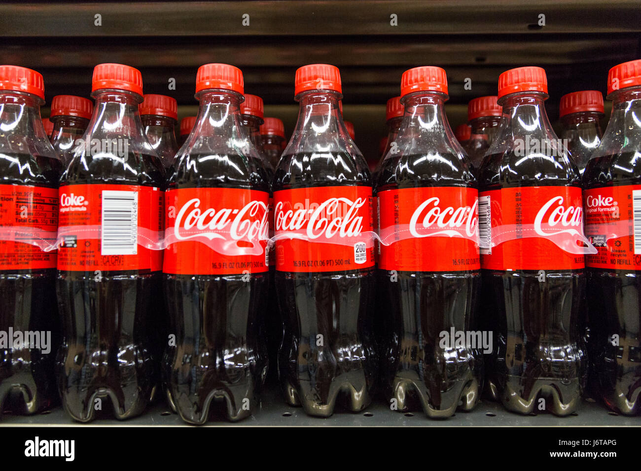 plastic bottles of Coca Cola on the shelf of a grocery store Stock Photo