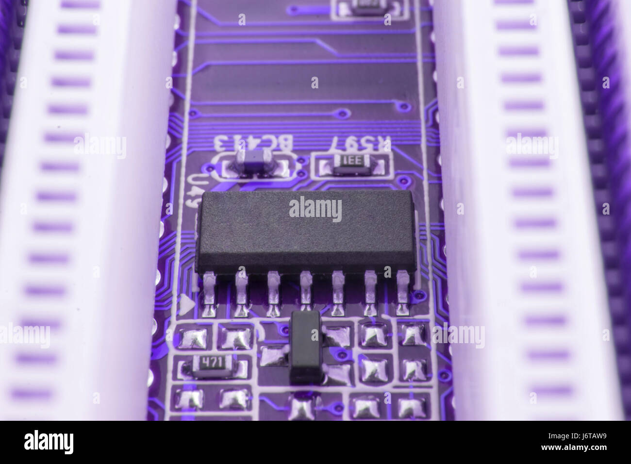 Chip on motherboard mainboard with controllers, ports and wires, close-up macro toned. Stock Photo