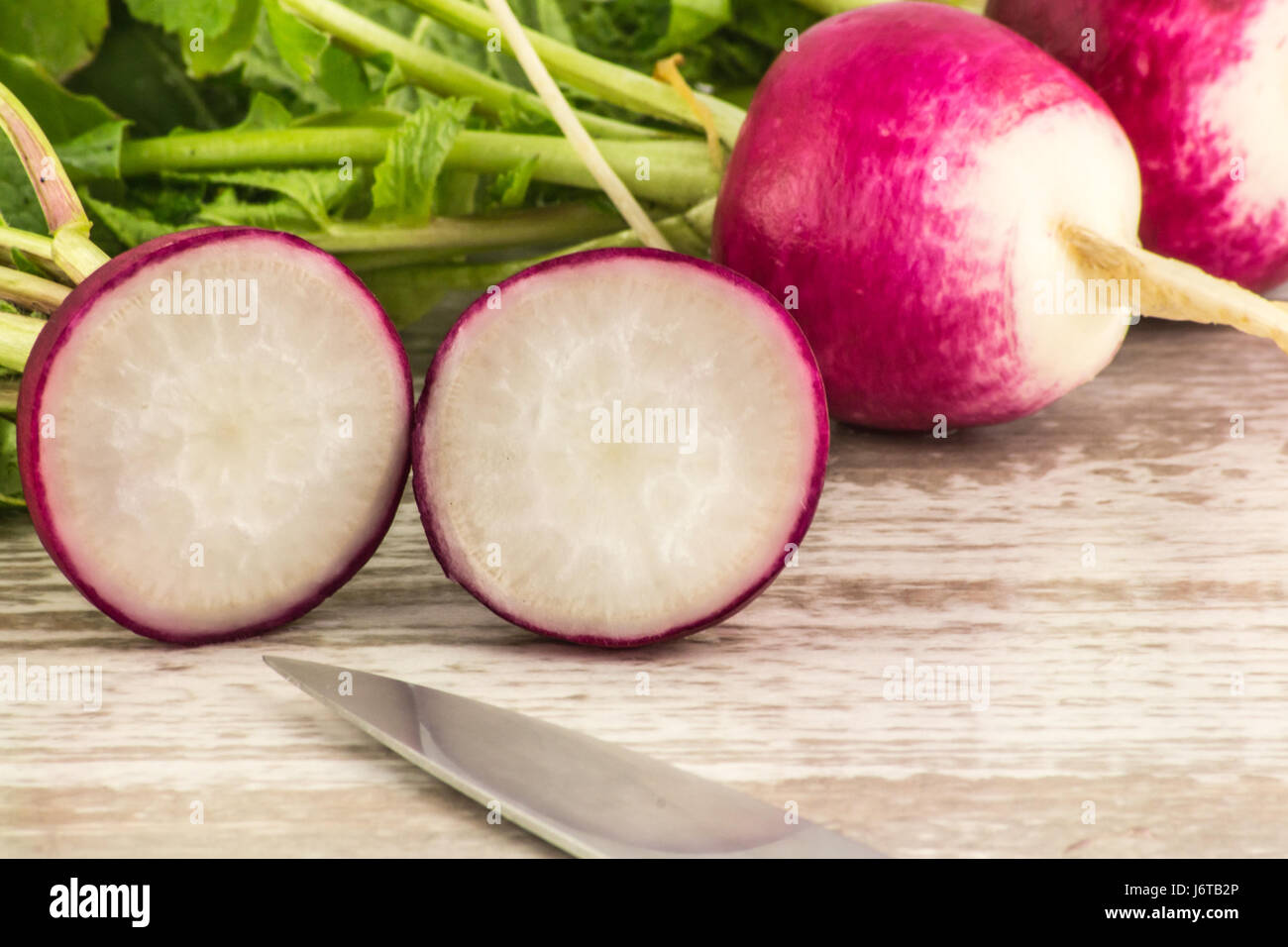 Juicy fresh radish in a cut on a white wooden background close up Stock Photo