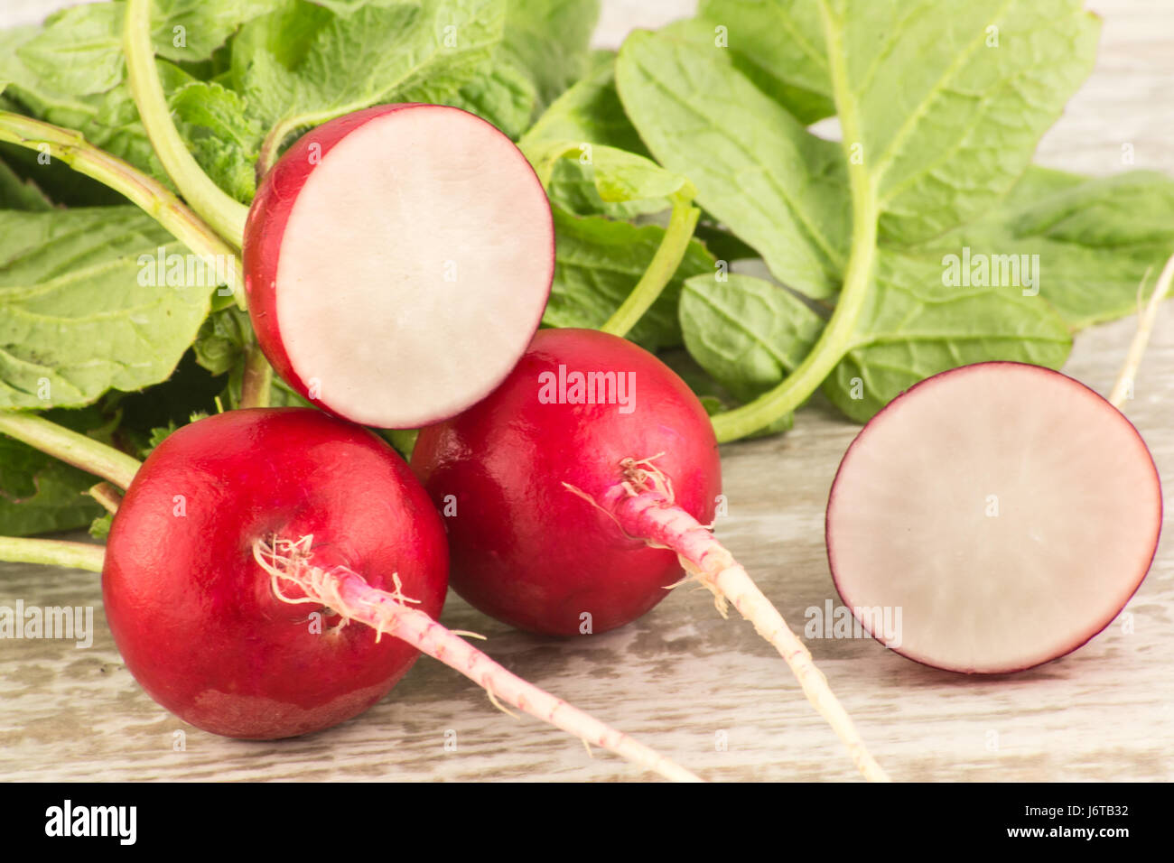 Juicy fresh radish in a cut on a white wooden background close up Stock Photo