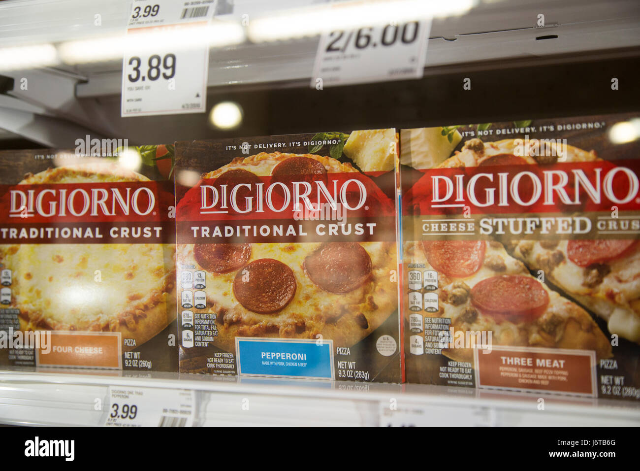 a display of DiGiorno frozen pizzas in a glass freezer case at a grocery store Stock Photo