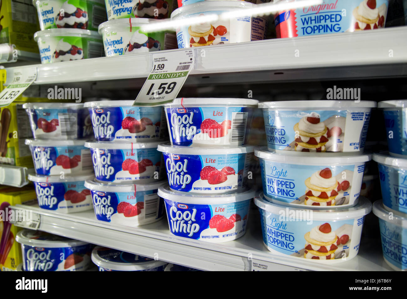 plastic tubs of Cool Whip in a refrigerator case of a grocery store
