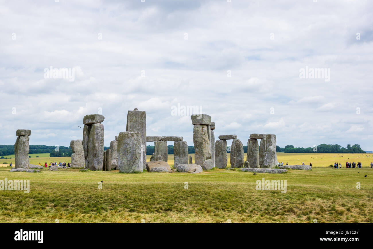 Stonehenge, Wiltshire, England with tourists and green fields in background Stock Photo
