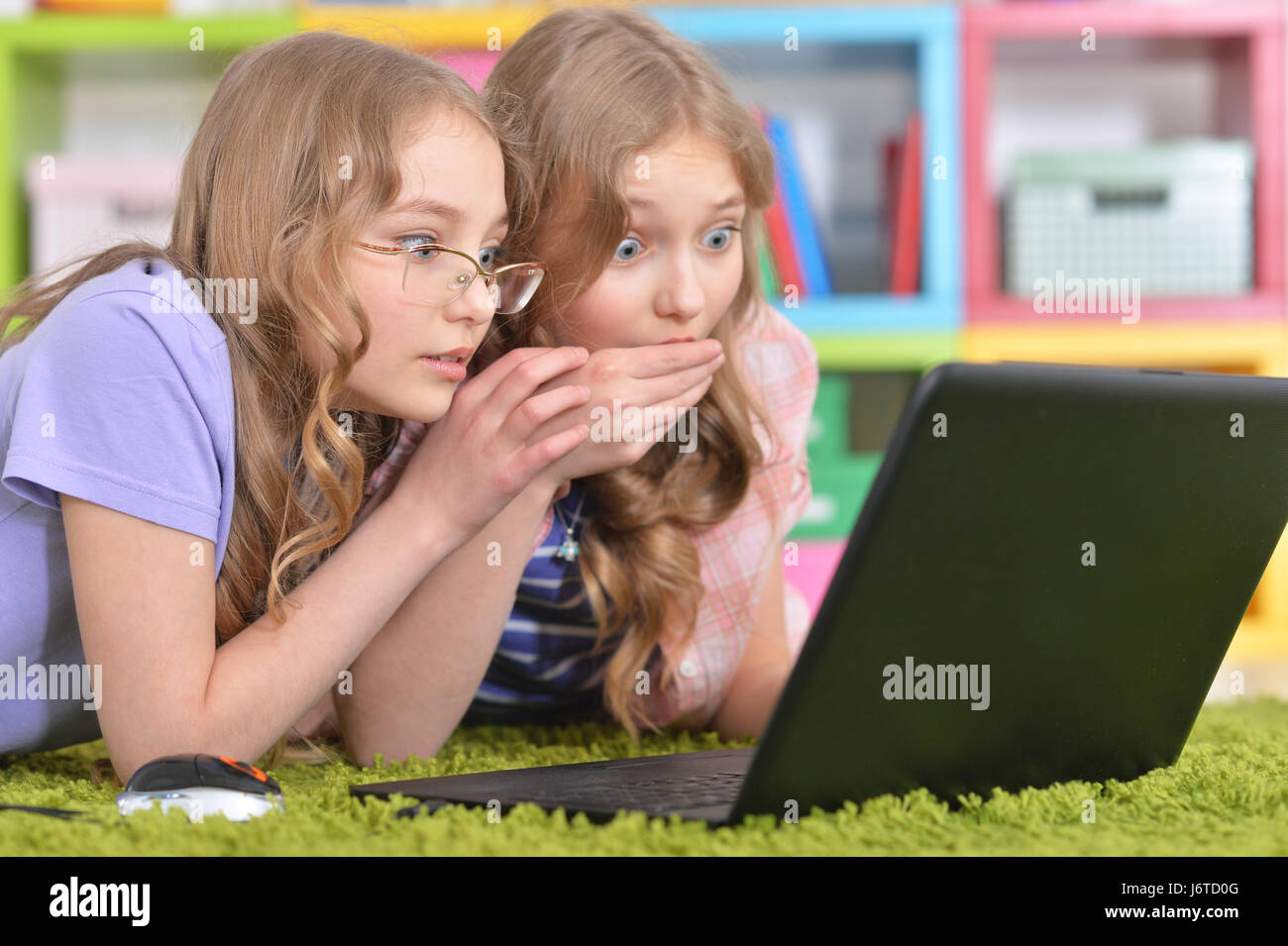 Teenagers sisters using laptop Stock Photo - Alamy