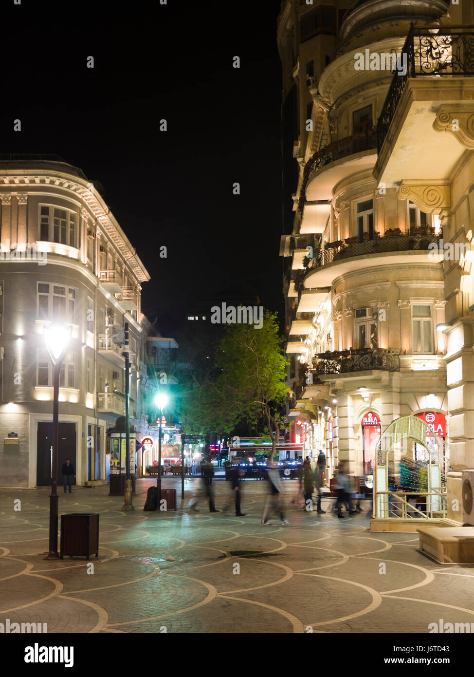 Night-time view of people and buildings in and around Nizami street, a shopping and pedestrian area in central Baku Azerbaijan Stock Photo