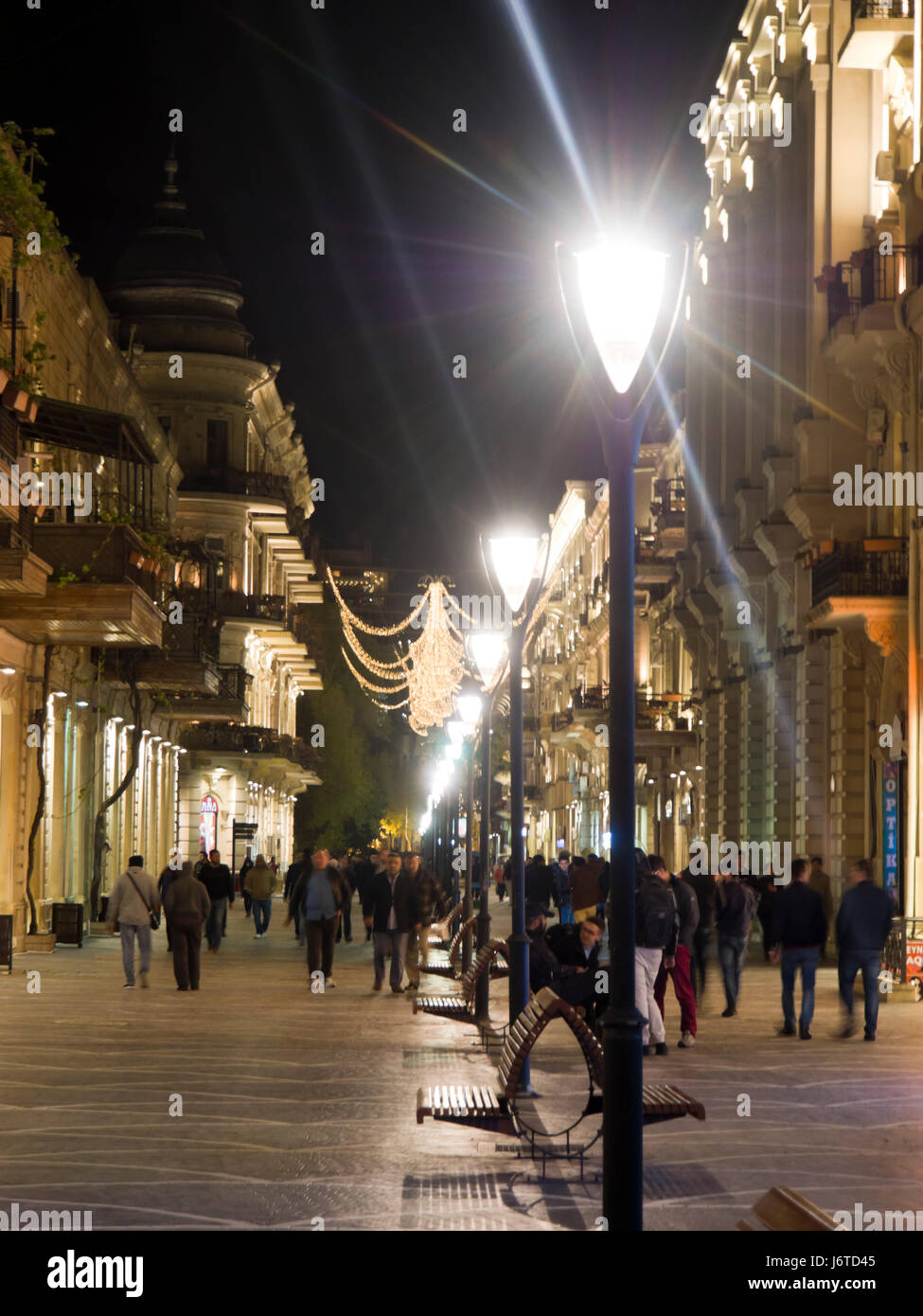 Night-time view of people and buildings in and around Nizami street, a shopping and pedestrian area in central Baku Azerbaijan Stock Photo