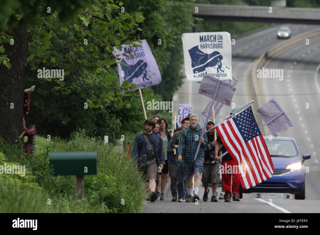 Harrisburg, PA., 21st May, 2017. A group of demonstrators, some of whom marched more than 100 miles from Philadelphia over the course of nine days, walk down the shoulder of US Route 322 near Hershey, PA, Sunday, May 21, 2017. The organizers plan on staging actions at the State Capitol building starting Monday, including planned civil disobedience. Credit: Michael Candelori/Alamy Live News Stock Photo