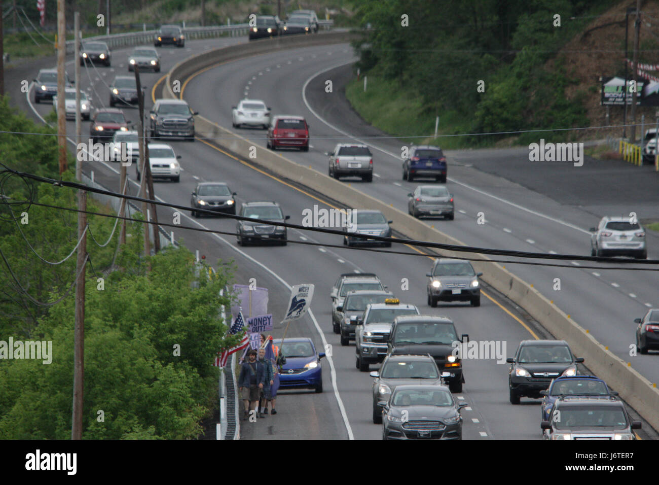 Harrisburg, PA., 21st May, 2017. A group of demonstrators, some of whom marched more than 100 miles from Philadelphia over the course of nine days, walk down the shoulder of US Route 322 near Hershey, PA, Sunday, May 21, 2017. The organizers plan on staging actions at the State Capitol building starting Monday, including planned civil disobedience. Credit: Michael Candelori/Alamy Live News Stock Photo