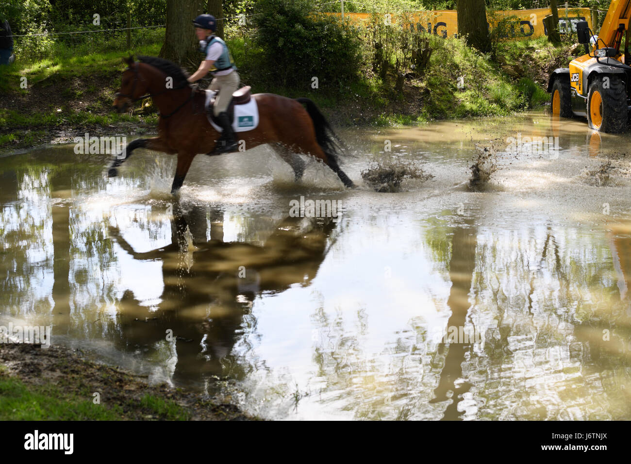 Rockingham Castle, Corby, UK. 21st May, 2017. Rider Alex Dance and his horse Count Danilo trot through the water hole on a sunny day during the cross country phase of the Rockingham International Horse Trials in the grounds of the Norman castle at Rockingham, Corby, England on 21st May 2017. Credit: miscellany/Alamy Live News Credit: miscellany/Alamy Live News Stock Photo