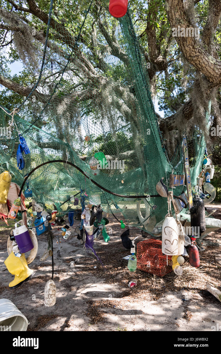 A sculpture made from waste and trash washed up in Jeremy Creek hangs