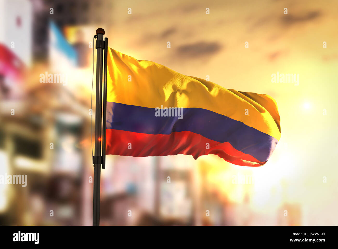Colombia Flag Against City Blurred Background At Sunrise Backlight Stock Photo