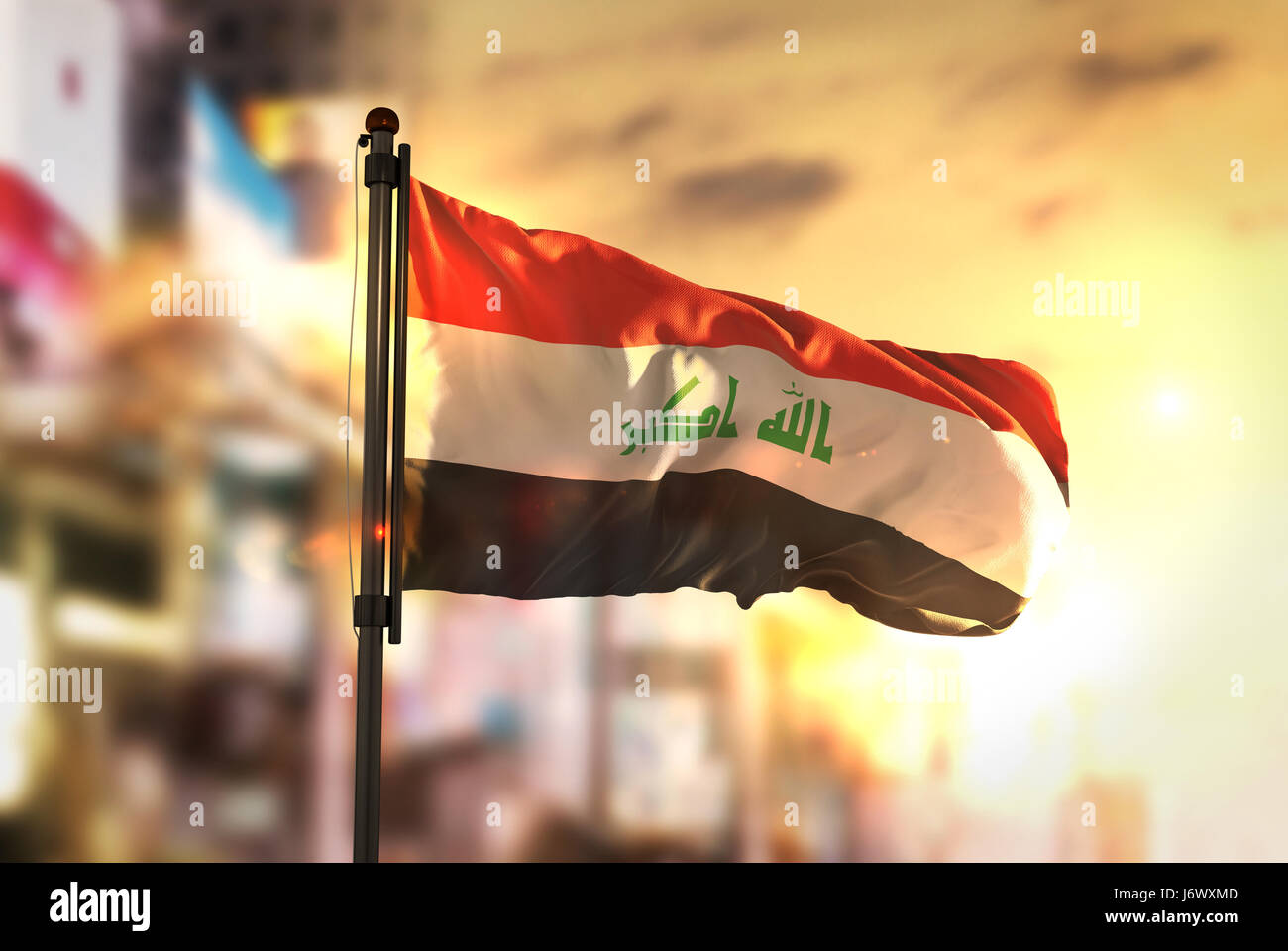 Iraq Flag Against City Blurred Background At Sunrise Backlight Stock Photo