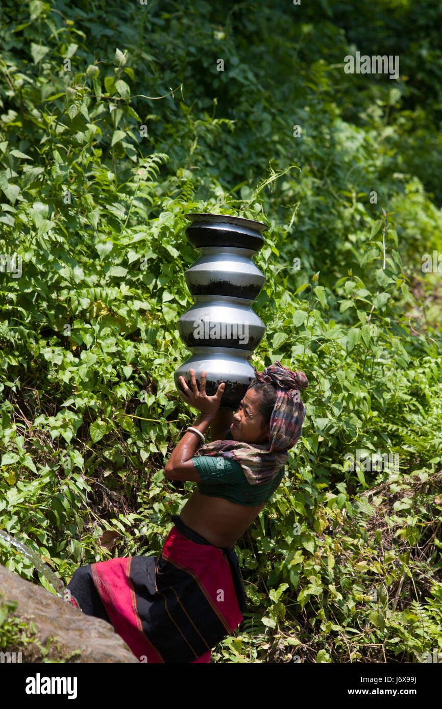 An ethnic woman carries water pots. Khagrachari, Bangladesh. Stock Photo