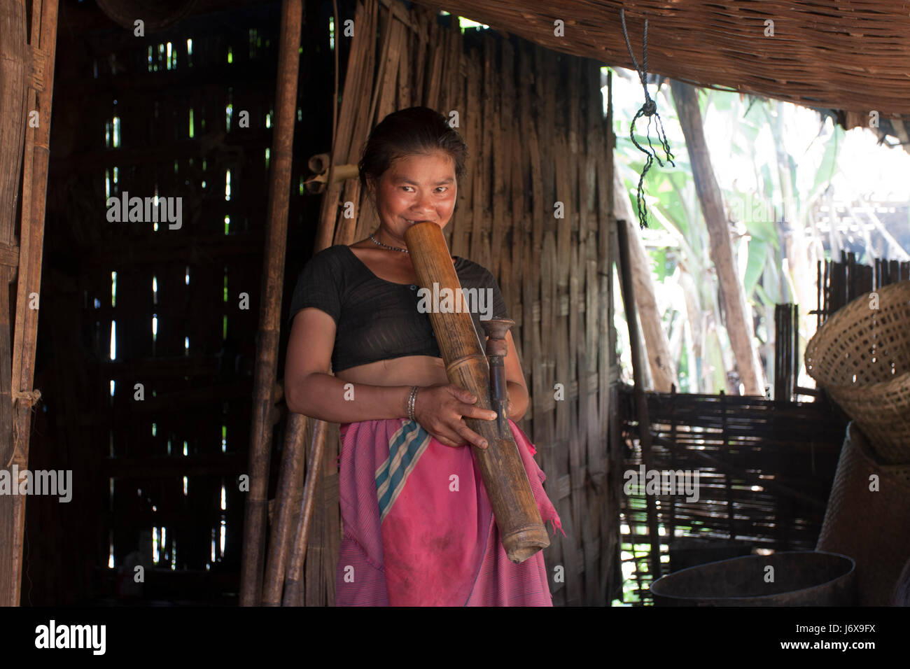 An ethnic woman smokes a traditional pipe. Khagrachari, Bangladesh. Stock Photo
