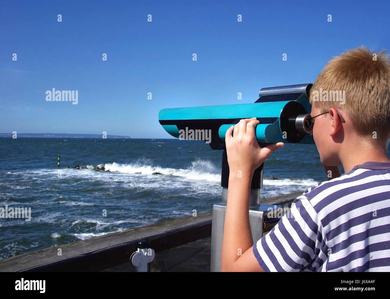 teenager looking through binoculars Stock Photo