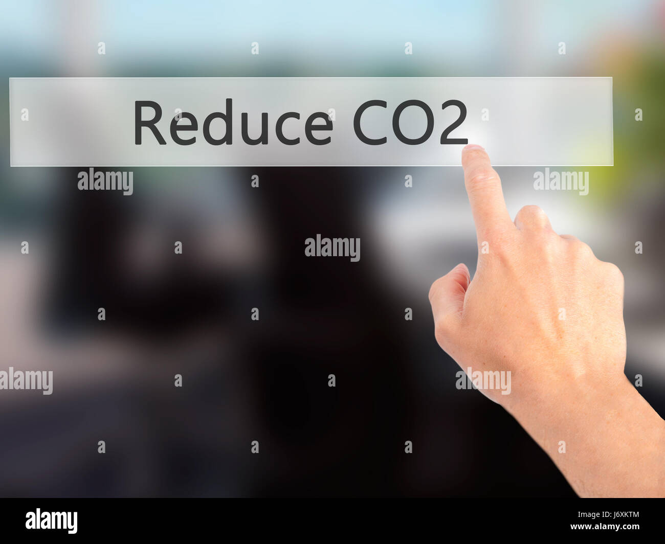 Reduce CO2 - Hand pressing a button on blurred background concept ...
