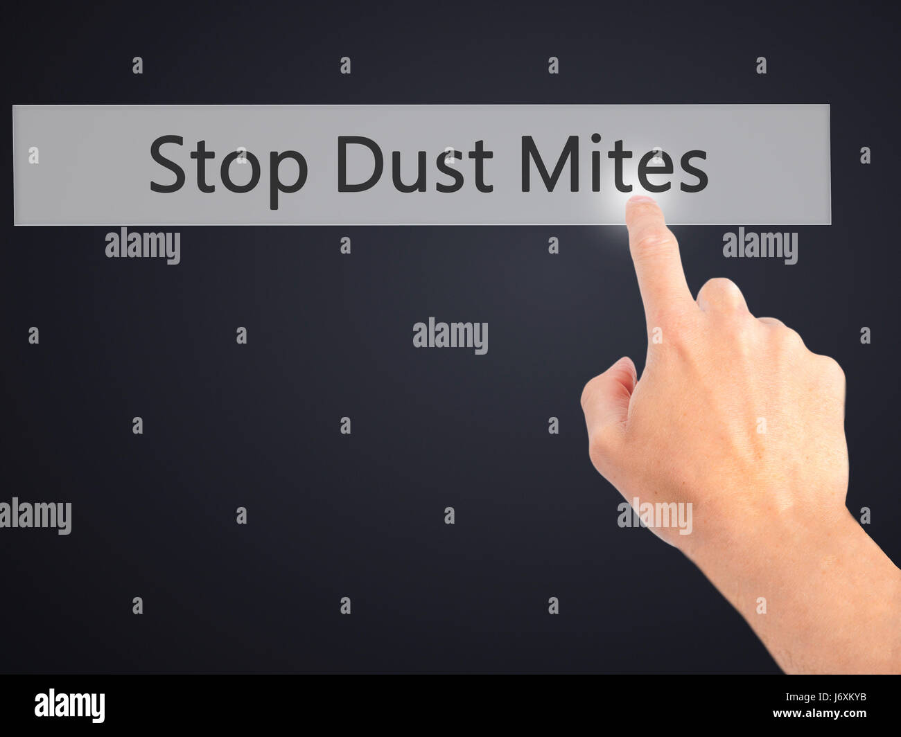 Stop Dust Mites Hand pressing a button on blurred background concept