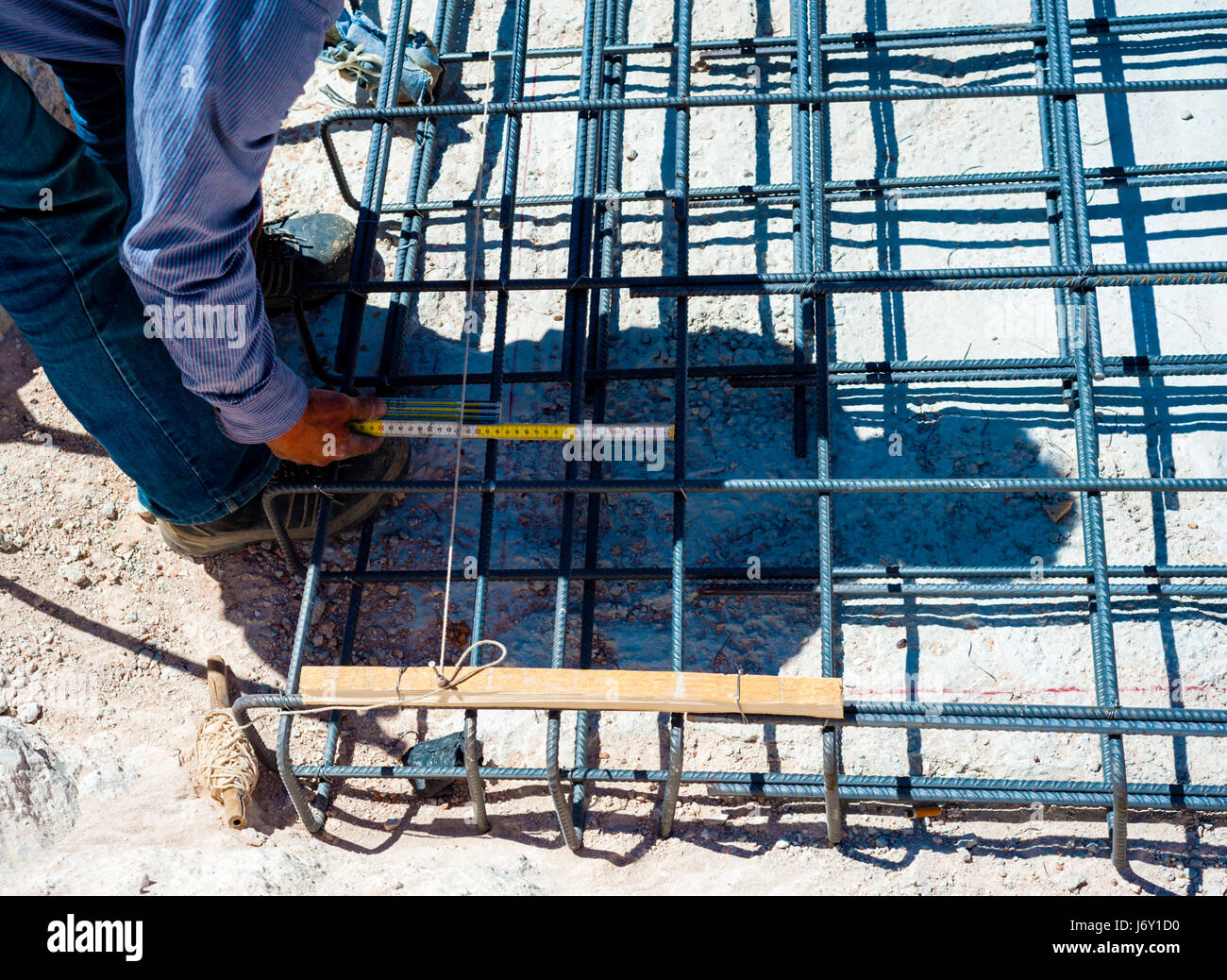 construction worker measuring distance of the foundation rebar in reinforced concrete Stock