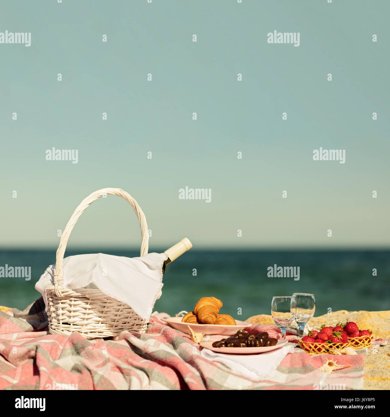 Summer time at the sea. Romantic picnic on the beach wine