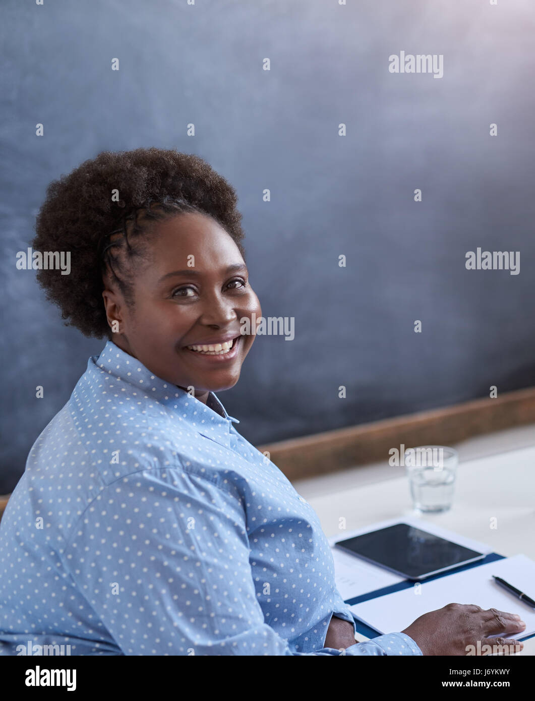 Smiling African businesswoman working in contemporary office Stock ...