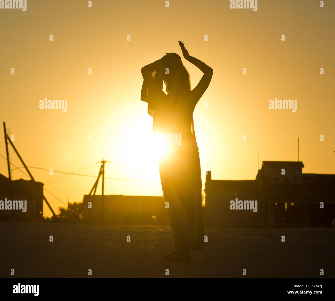 girl's silhouette against the sun at sunset Stock Photo