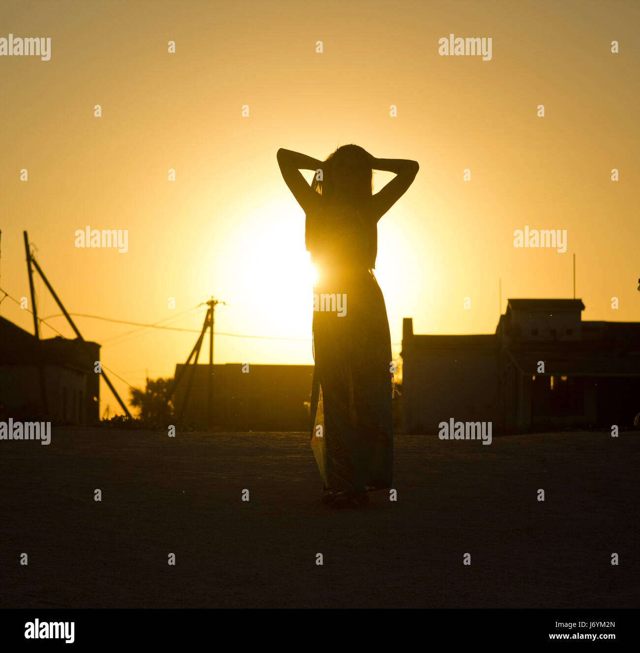 girl's silhouette against the sun at sunset Stock Photo