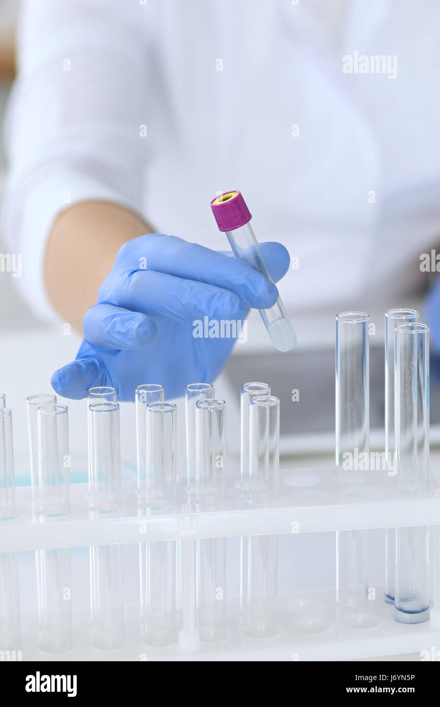 Close up of scientific research hands with clear solution in laboratory ...