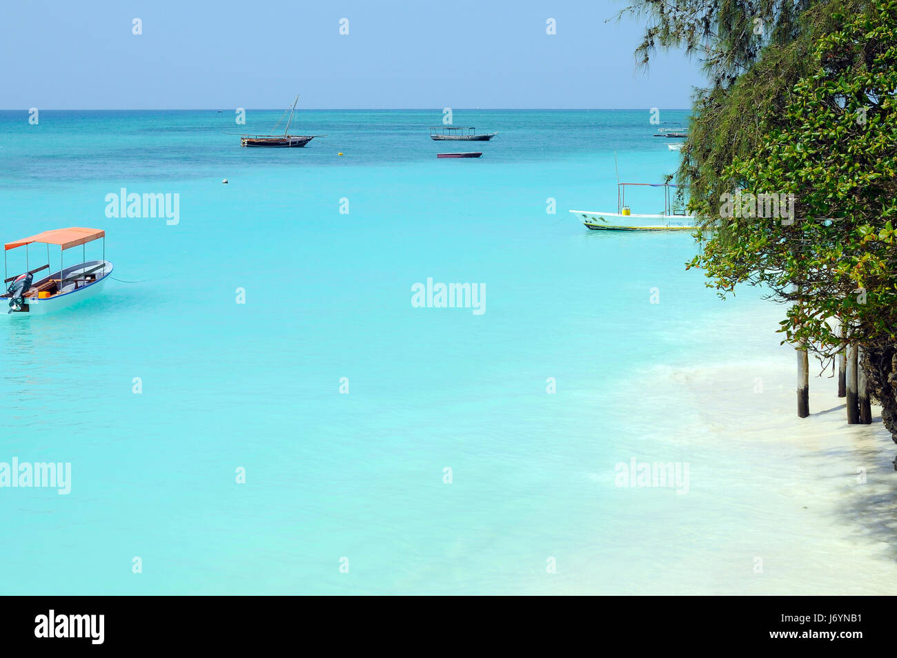 Crystal clear waters at Zanzibar beach. Safety boat on the paradise