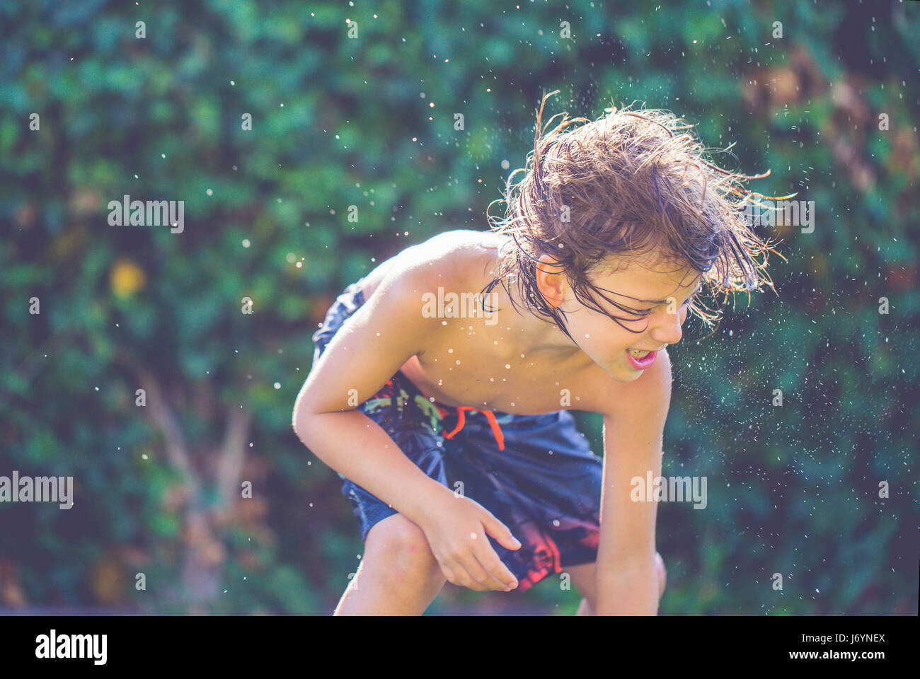 Boy with wet hair splashing in river Stock Photo