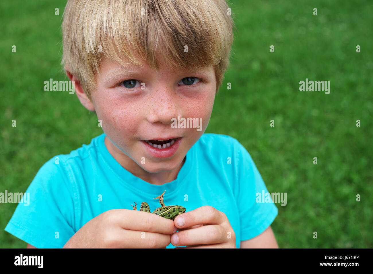 Portrait of a boy holding a frog Stock Photo