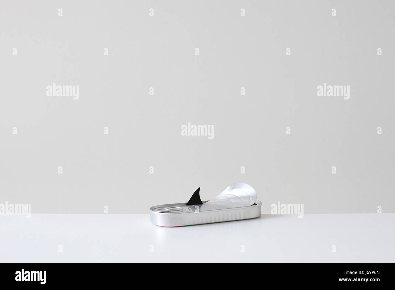 Conceptual Shark fin opening a tin to escape Stock Photo