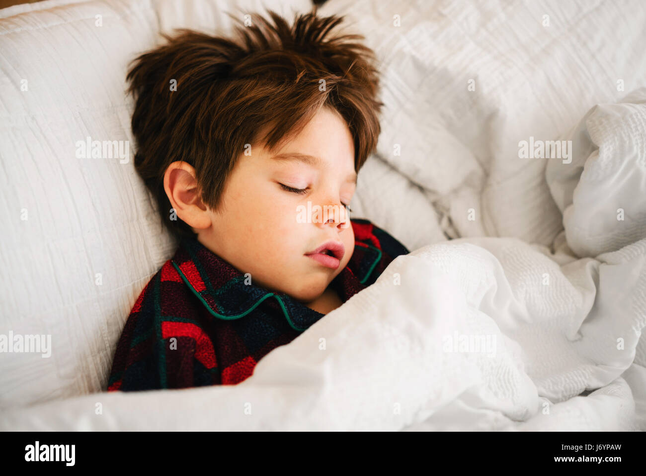Boy lying in bed sleeping Stock Photo