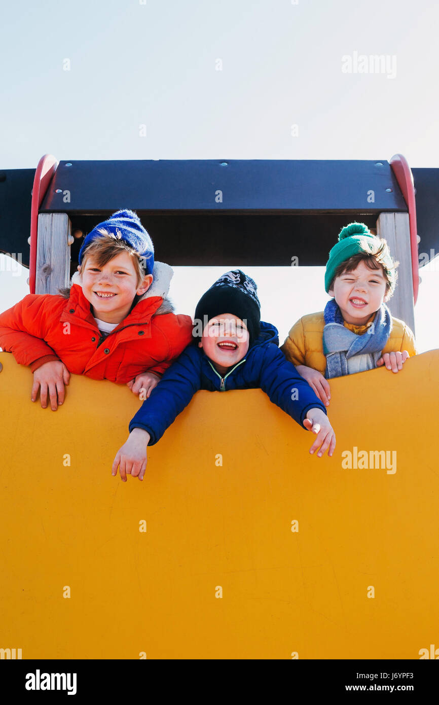 Three boys playing at a playground Stock Photo
