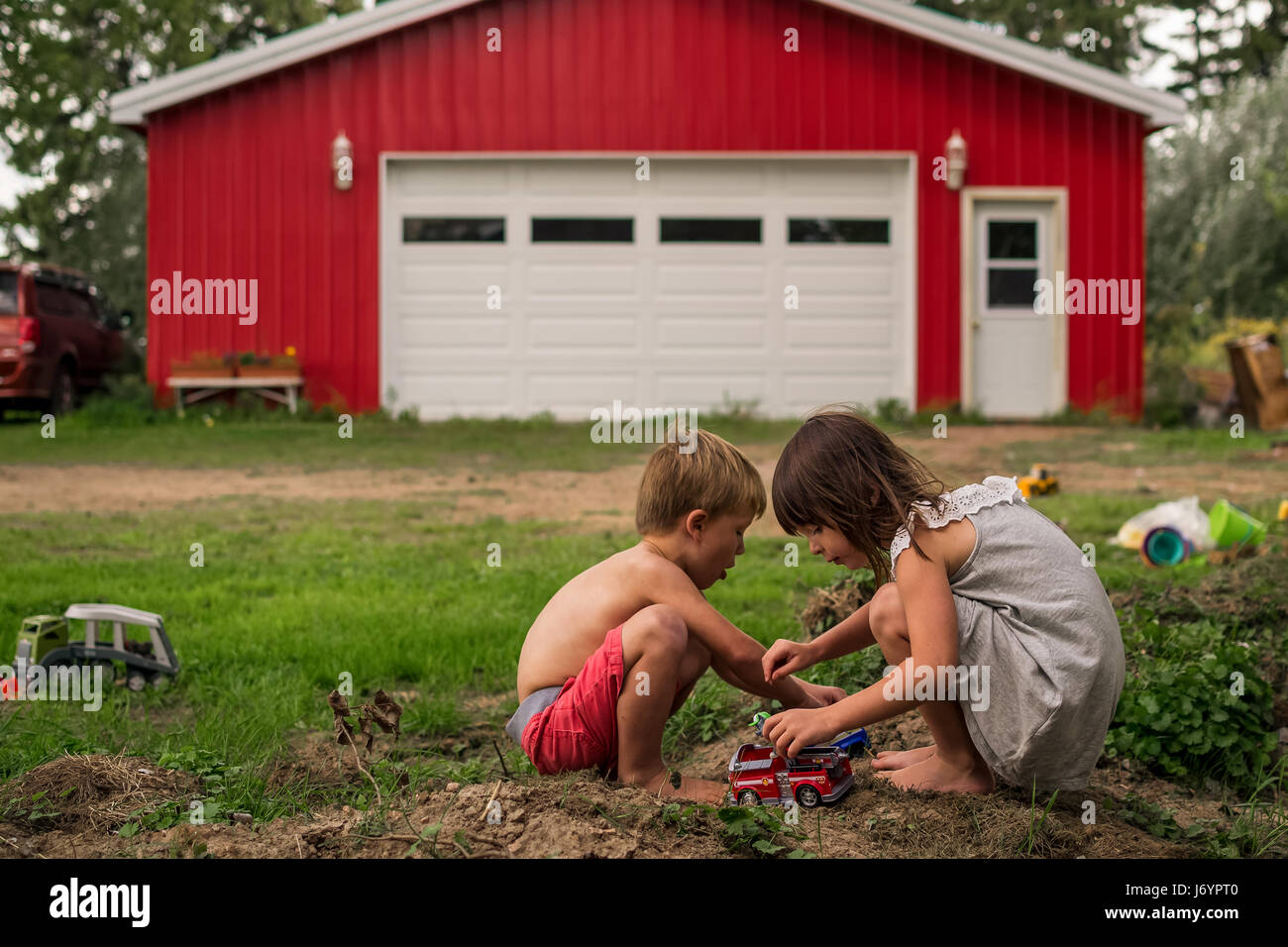 Boy and girl playing with toy cars Stock Photo