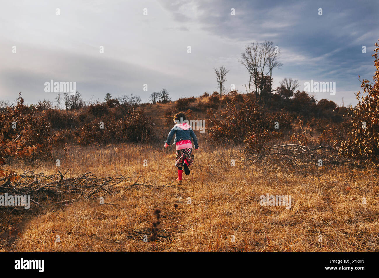 Girl running up a hill Stock Photo Alamy